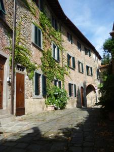 博尔格阿布贾诺antica casa "le rondini"的一座石头建筑,旁边是常春藤