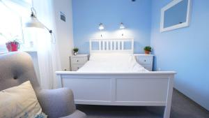 普沃茨克MCEW Studnia的蓝色客房的一张白色床和椅子