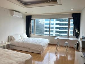 首尔Hongik univ station Exit 1的卧室配有一张床和一张桌子及椅子