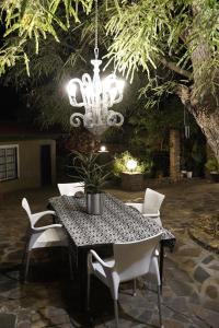 温特和克EXQUISITE PRIVATE LUXURY SUITE WITH KING BED at BOKMAKIERIE VILLAS的餐桌、椅子和吊灯
