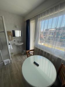 日内瓦Primadom Aparthotel的客房设有白色桌子、水槽和窗户。