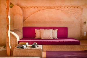 比利亚埃尔莫萨德尔里奥玛德拉卡拉斯卡旅馆的一张床位,位于一个配有粉红色长凳的房间