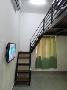 瓜拉丁加奴Tiny House Idaman Kuala Terengganu with Private House的楼梯,房间带窗帘和电视
