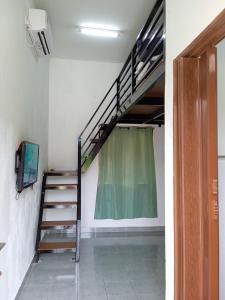 瓜拉丁加奴Tiny House Idaman Kuala Terengganu with Private House的一间设有楼梯的房间和客房内的电视