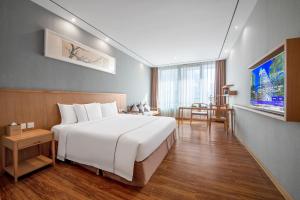 广州广州珠江新城华轩里酒店的卧室配有一张白色的大床和一张桌子