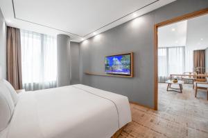 广州广州珠江新城华轩里酒店的一间带白色床的卧室和一间客厅