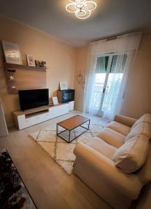 雷诺河畔卡萨莱基奥EDC home con parcheggio e self check in的客厅配有白色沙发和电视