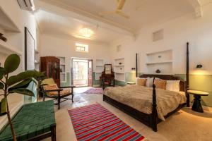 斋浦尔Sum Jaipur的一间卧室配有一张床、一把椅子和一张桌子