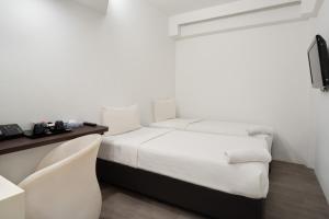 新加坡Lion Peak Dickson的白色的客房配有一张床和一张书桌