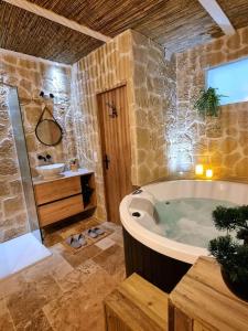 勒格罗-迪鲁瓦Les Spas de la mer, Suite & Spa, Love room, Plein Cœur du Grau的带浴缸和盥洗盆的大浴室