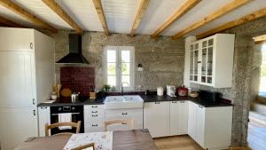 塞亚Quinta da Cumieira Nova的厨房配有白色橱柜和木制天花板