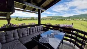 科雷尼察House Boketto的阳台享有田野美景,配有一张沙发和桌子。
