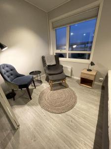斯沃尔韦尔Vestfjordgata Apartment 24的客厅配有两把椅子、一把椅子和一张桌子
