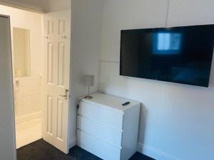 南安普敦Circle Guest House Bed Only的一间设有电视的壁挂式客房,配有冰箱