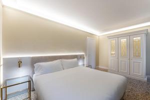 威尼斯San Vio Palace Luxury Apartments的一间白色的卧室,配有床和门