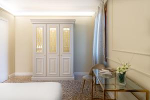 威尼斯San Vio Palace Luxury Apartments的一间设有门、桌子和椅子的房间