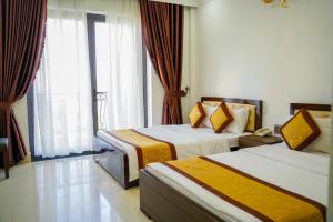 顺化Dat Anh Hotel的酒店客房设有两张床和窗户。