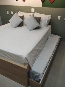 圣劳伦斯海滨Flat Amarilis Apartamento 202的一张配有白色床单和枕头的大床