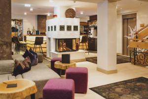 萨尔巴赫迪耶索恩酒店的客厅设有壁炉和紫色椅子