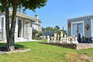 格拉罕镇Villa Palesa Guesthouse的房屋前有巨型棋盘的院子