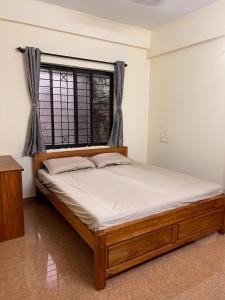 乌杜皮City Center Apartments的窗户和床架的房间的一张床位