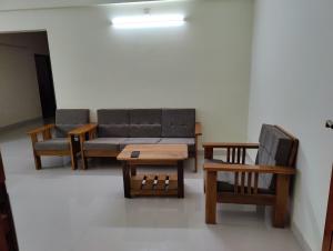 乌杜皮City Center Apartments的一间配有沙发、两把椅子和一张桌子的房间