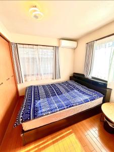 东京吉吉の家的配有2扇窗户的客房内的1张床