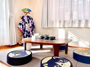 东京吉吉の家的客厅配有桌子和两把脚凳