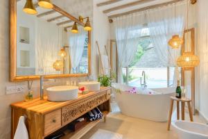 桑给巴尔Zanzi Resort的浴室设有2个水槽、浴缸和镜子