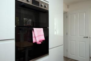 纽波特4BR modern house Free Parking Cohost Partners的厨房配有黑色烤箱,提供红白毛巾