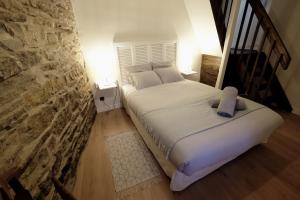 马西亚克la Ferme de Vazerat的石墙房间内的一张床位