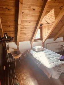 萨尔格米纳LA MARIEFACTURE - Comme Si comme Fa的一间带一张床的卧室,位于带木制天花板的房间内