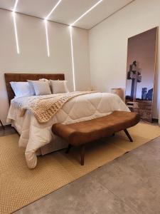 圣米格尔-达斯米松伊斯Pousada das Missoes的一间卧室配有一张大床和一张长凳