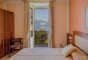 韦尔巴尼亚Hotel Belvedere San Gottardo的一间卧室设有一张床和一个美景阳台