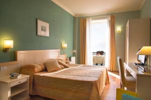 韦尔巴尼亚Hotel Belvedere San Gottardo的一间带床的卧室,位于带窗户的房间内