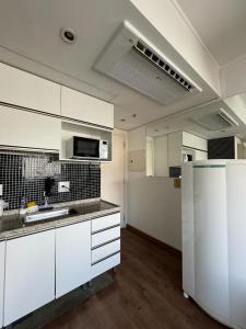 圣保罗Studio Living Slavieiro Moema的空厨房配有白色橱柜和冰箱