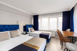 伊斯坦布尔Sirkeci Grand Family Hotel & SPA的酒店客房设有两张床和一张桌子。