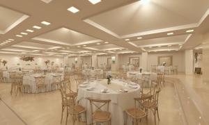 罗列特海岸Meliá Lloret de Mar的一个带白色桌椅的大型宴会厅