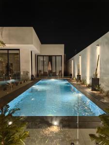 Al Wudayyمنتجع LA的一座晚上在房子里的大型游泳池