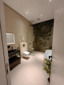 Al Wudayyمنتجع LA的大型浴室设有卫生间和水槽。