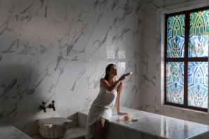 拉瑞Swandor Hotels & Resorts - Topkapi Palace的坐在浴室浴缸边缘的女人