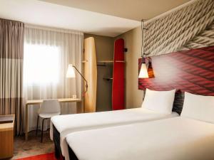 波尔多波尔多中心巴斯蒂德宜必思酒店的酒店客房设有两张床,墙上设有冲浪板。
