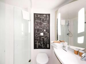波尔多波尔多中心巴斯蒂德宜必思酒店的浴室墙上挂着黑白照片
