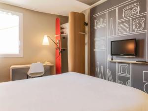 波尔多波尔多中心巴斯蒂德宜必思酒店的一间卧室配有一张床,墙上配有电视