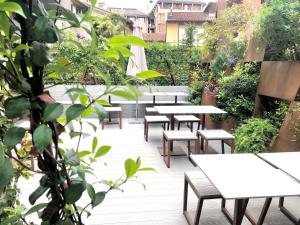 波代诺内波代诺内公园贝斯特维斯塔优质酒店的花园中的一排桌子和长椅