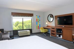坎顿亚特兰大广汉普顿酒店的酒店客房配有一张床、一张书桌和一台电视。
