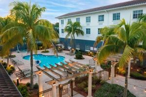 圣露西港圣露西港/美国职业高尔夫球协会村希尔顿花园酒店的享有酒店游泳池和棕榈树的景色