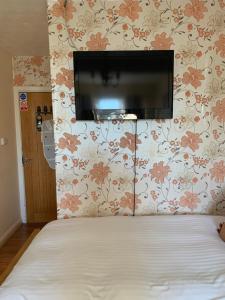 剑桥园景宾馆的卧室配有一张床铺,墙上配有电视