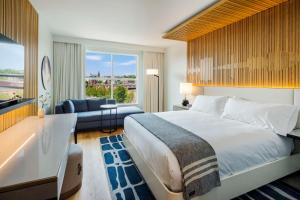 波特兰Canopy By Hilton Portland Waterfront的酒店客房设有一张大床和一个浴缸。