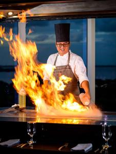 坎昆Hilton Cancun Mar Caribe All-Inclusive Resort的厨师在火焰前准备食物